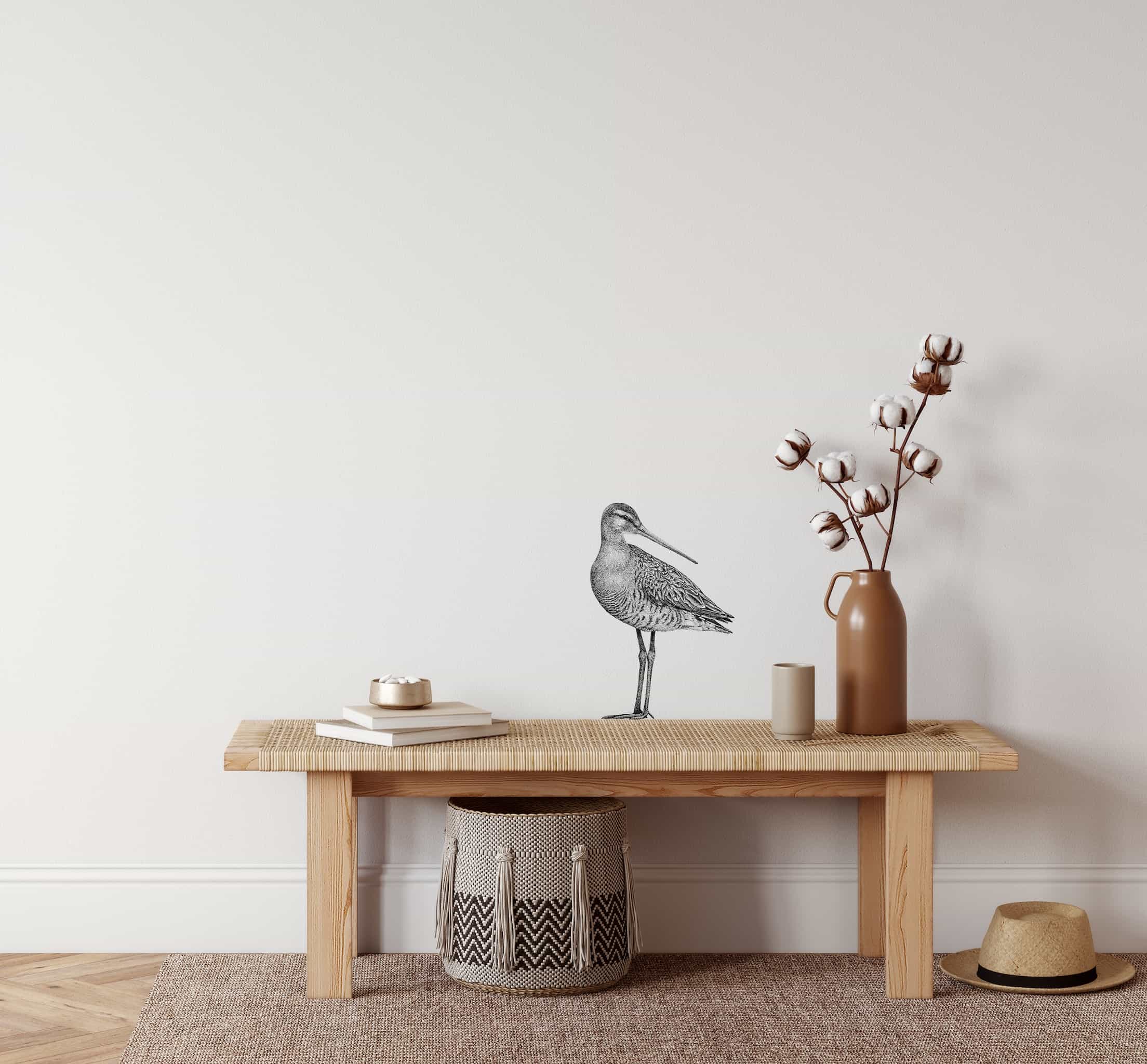 houten bankje met getekende vogel op muur