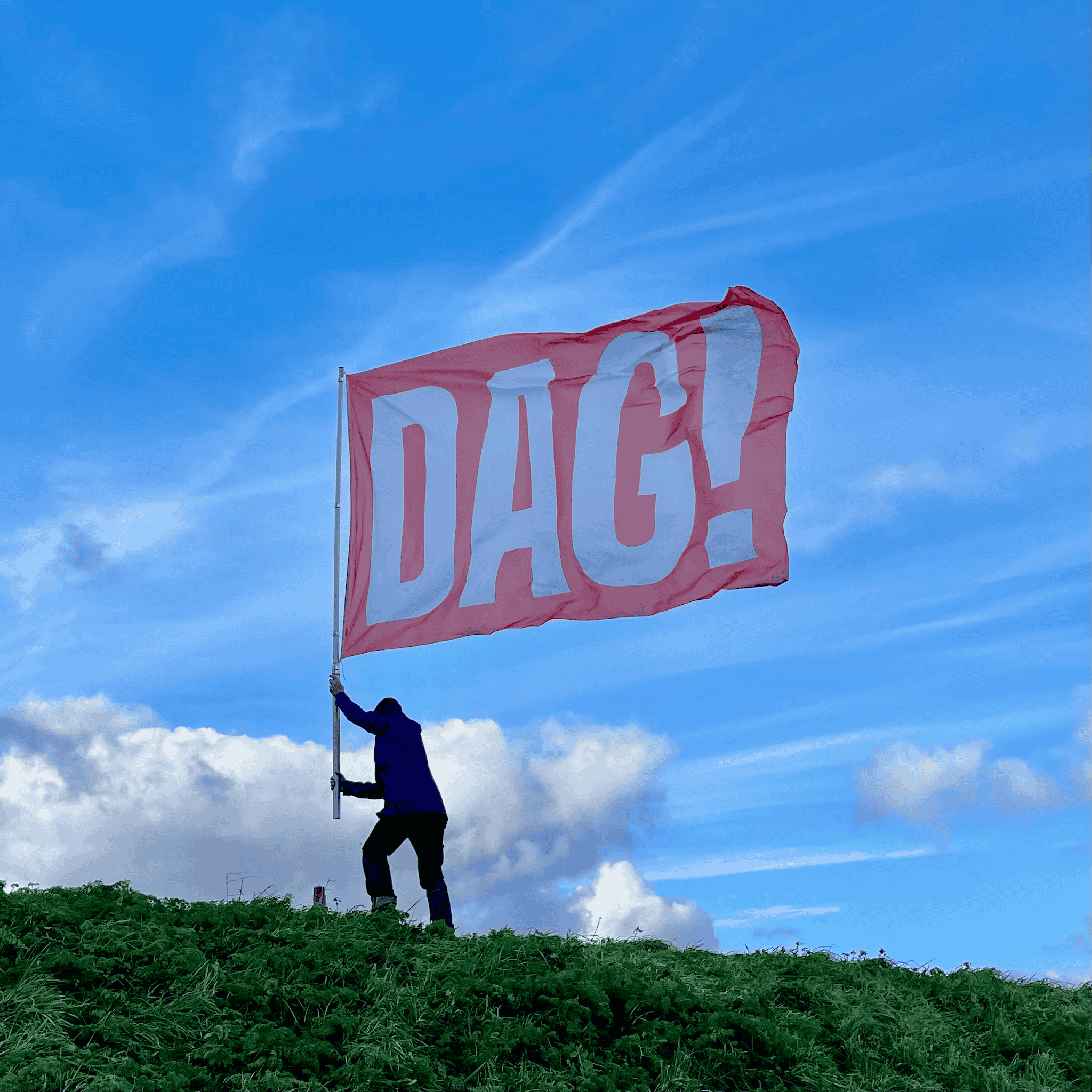 persoon met rode vlag met dag in veld